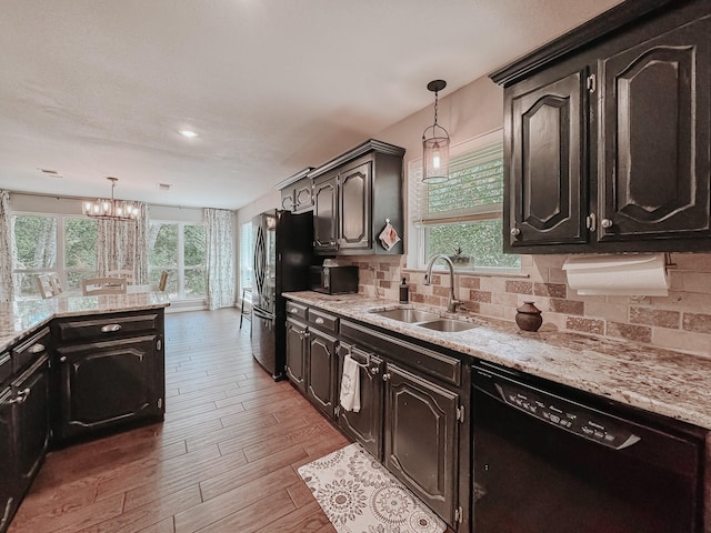 kitchen with decorative backsplash, sink, hanging light fixtures, and black appliances