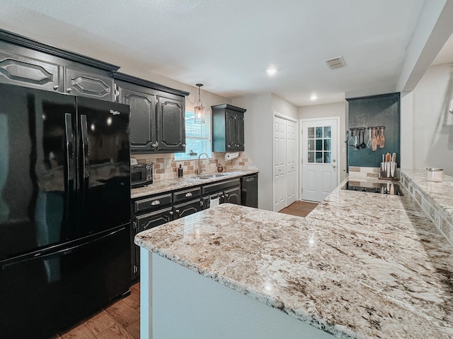 kitchen featuring black appliances, dark wood-type flooring, tasteful backsplash, sink, and hanging light fixtures