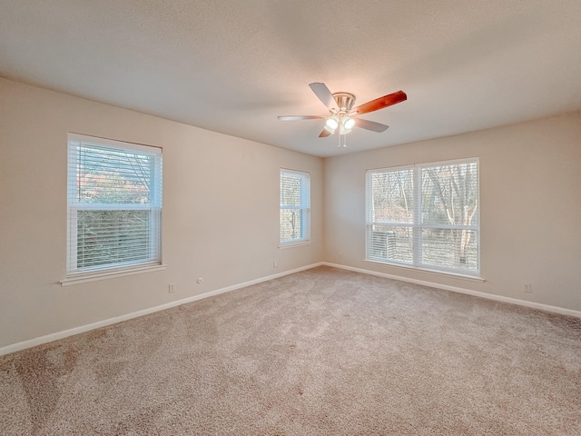 carpeted empty room with ceiling fan and a healthy amount of sunlight