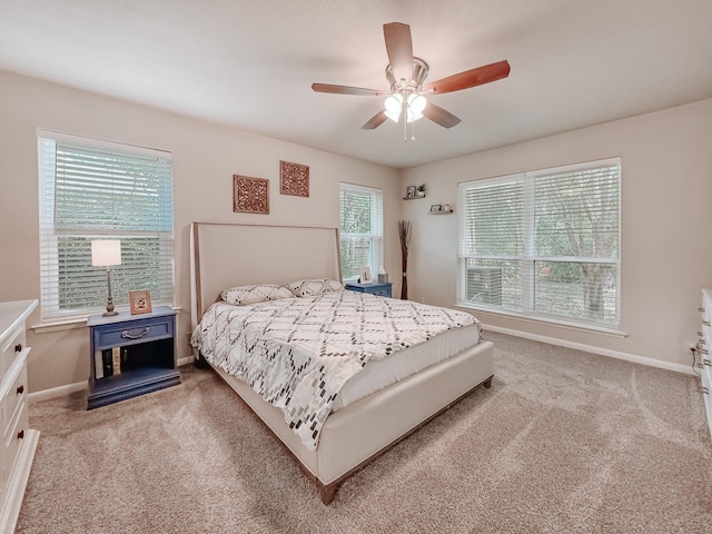 carpeted bedroom featuring ceiling fan and multiple windows