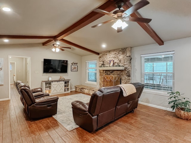 living room featuring a fireplace, lofted ceiling with beams, ceiling fan, and light wood-type flooring