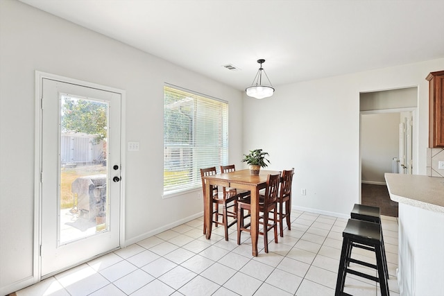 dining space featuring light tile patterned floors, plenty of natural light, visible vents, and baseboards