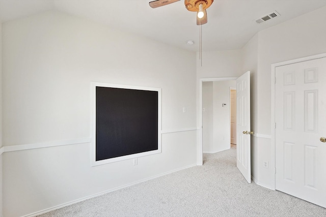 unfurnished bedroom with visible vents, baseboards, lofted ceiling, ceiling fan, and carpet floors