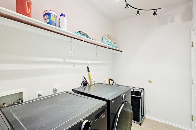 laundry area featuring laundry area, washer and clothes dryer, and baseboards