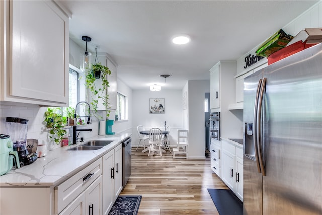 kitchen featuring sink, appliances with stainless steel finishes, white cabinetry, and light hardwood / wood-style floors