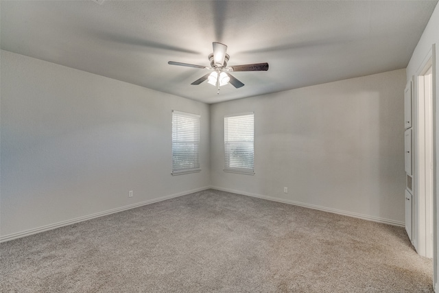 carpeted spare room with ceiling fan