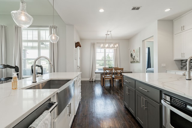 kitchen with decorative light fixtures, light stone counters, white cabinetry, gray cabinets, and dark hardwood / wood-style floors