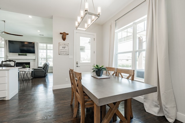 dining area featuring ceiling fan with notable chandelier and dark hardwood / wood-style flooring