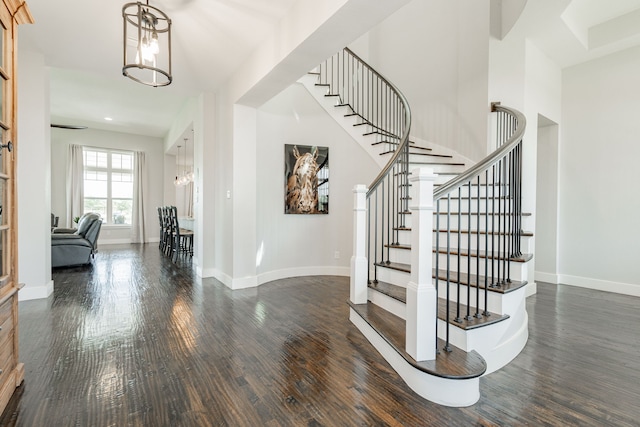 foyer entrance with dark hardwood / wood-style floors and a chandelier