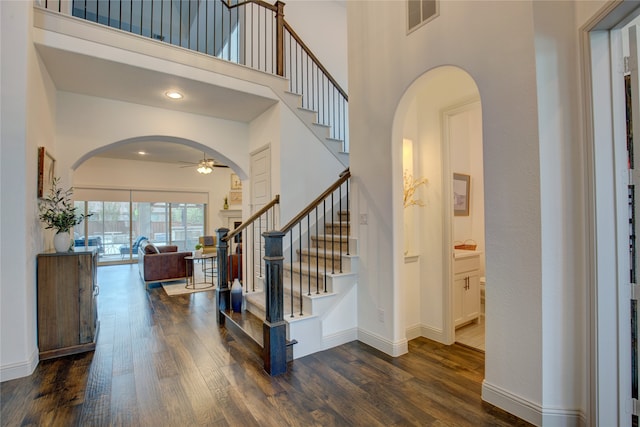 entrance foyer with dark wood-type flooring, a high ceiling, and ceiling fan