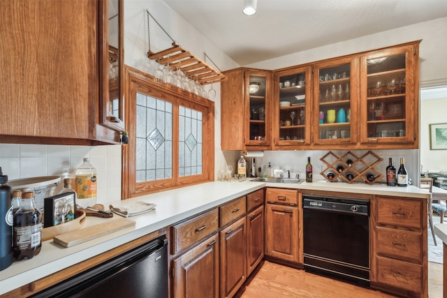 kitchen featuring dishwasher, light wood-type flooring, tasteful backsplash, and sink