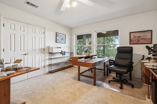 carpeted office space with ceiling fan