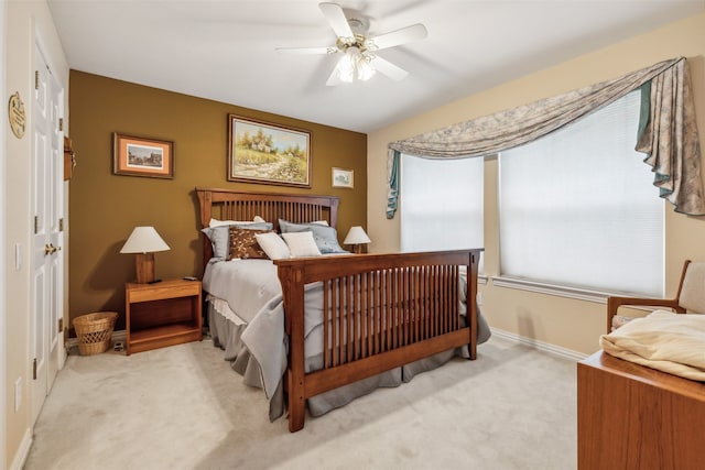 bedroom featuring light colored carpet, ceiling fan, and a closet