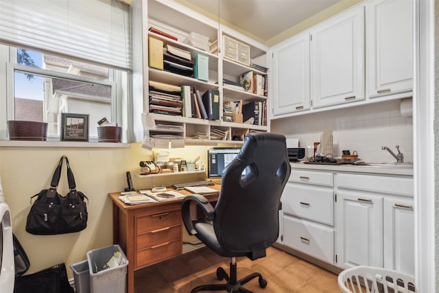 office space featuring built in desk, light tile patterned floors, and sink