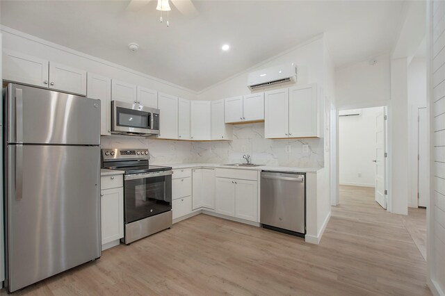 kitchen featuring stainless steel appliances, sink, ceiling fan, lofted ceiling, and an AC wall unit