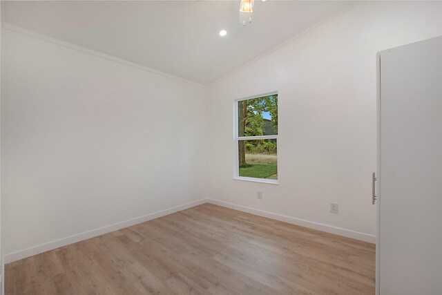 unfurnished room with crown molding, vaulted ceiling, and light hardwood / wood-style floors