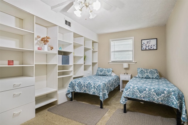 carpeted bedroom with a textured ceiling and ceiling fan