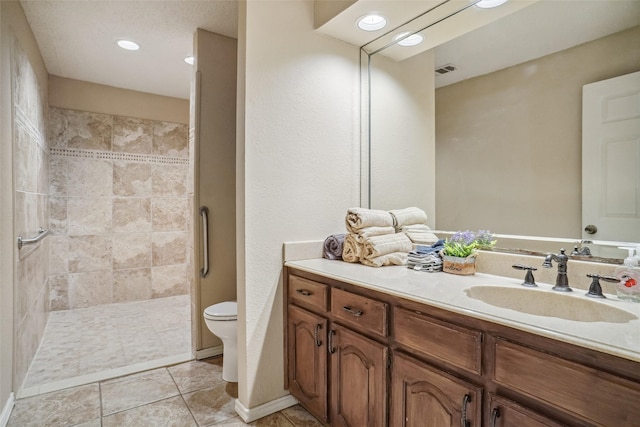 bathroom with tile patterned floors, tiled shower, toilet, and vanity