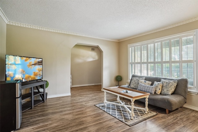 living room featuring ornamental molding, dark hardwood / wood-style flooring, and a textured ceiling