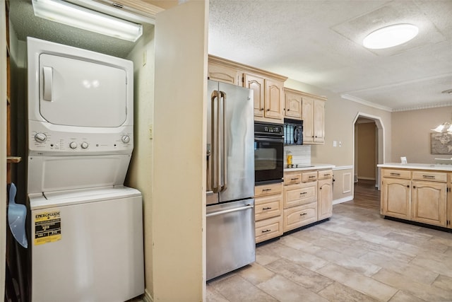 laundry area with stacked washer and clothes dryer, ornamental molding, and a textured ceiling