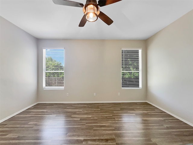 empty room with dark hardwood / wood-style flooring and ceiling fan