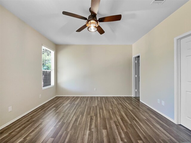 unfurnished room featuring dark wood-type flooring and ceiling fan