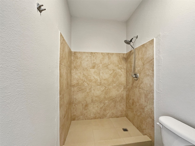 bathroom featuring toilet and a tile shower