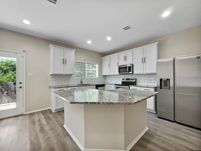 kitchen featuring appliances with stainless steel finishes, a wealth of natural light, and a kitchen island