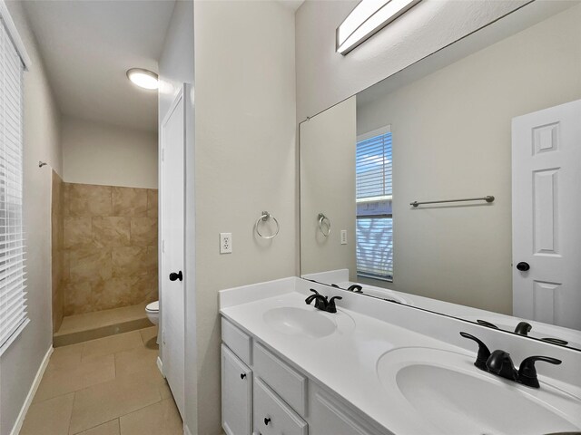 bathroom featuring tile patterned flooring, vanity, toilet, and walk in shower