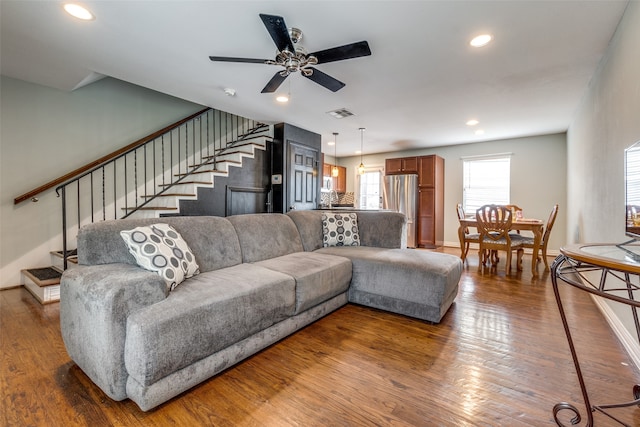 living room featuring ceiling fan and dark wood-type flooring