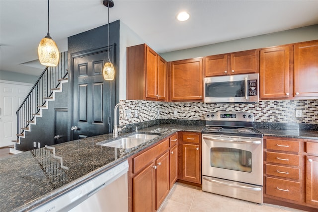 kitchen with decorative backsplash, decorative light fixtures, stainless steel appliances, and sink