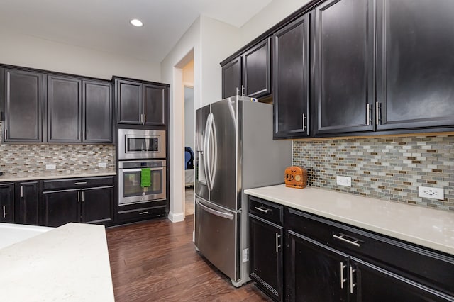 kitchen featuring dark wood-type flooring, backsplash, and stainless steel appliances