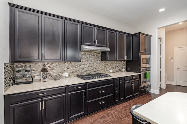 kitchen with stainless steel appliances, backsplash, and dark hardwood / wood-style flooring