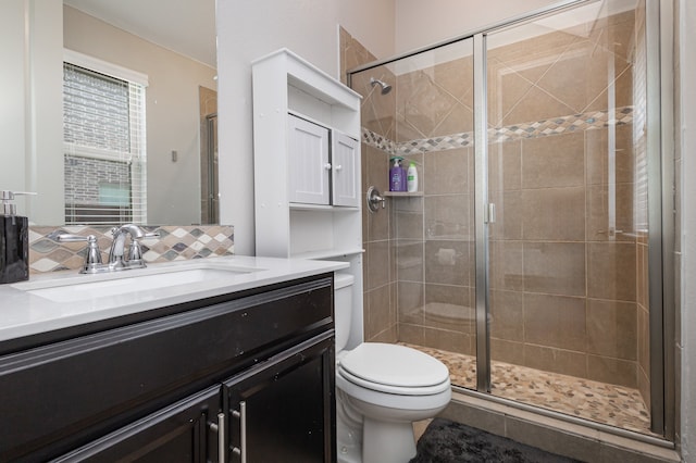 bathroom with toilet, vanity, and a shower with door