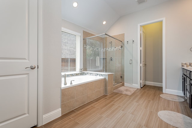 bathroom with independent shower and bath, vanity, and lofted ceiling