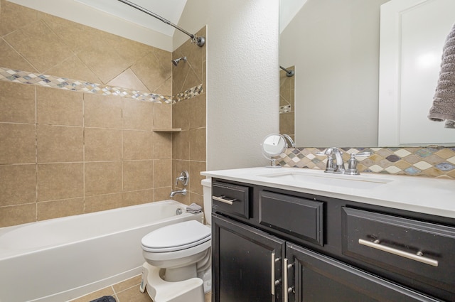 full bathroom featuring tiled shower / bath, vanity, tile patterned floors, toilet, and decorative backsplash