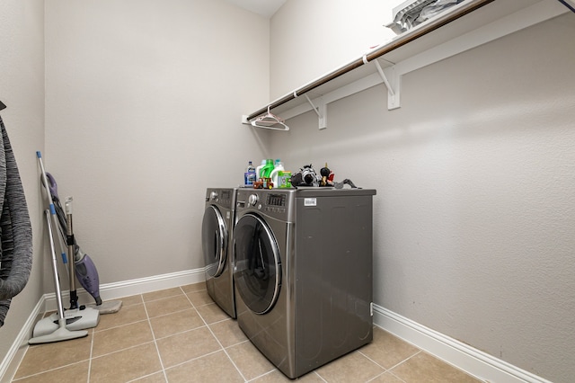 clothes washing area with light tile patterned floors and independent washer and dryer