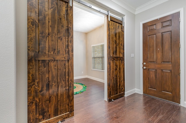 entrance foyer featuring ornamental molding, a barn door, and dark hardwood / wood-style floors