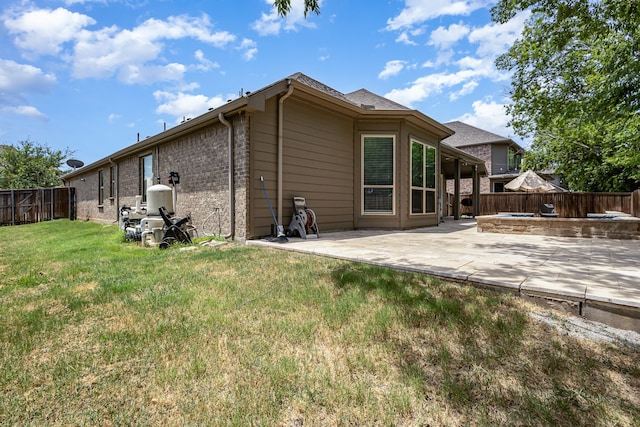 rear view of property with a patio and a lawn