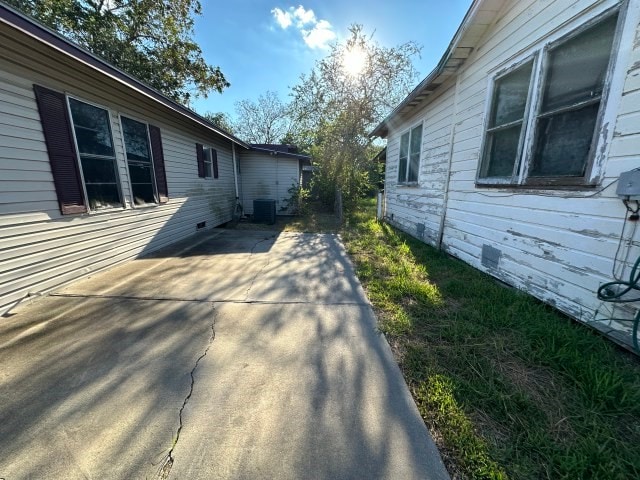 view of side of home with a patio area and central air condition unit