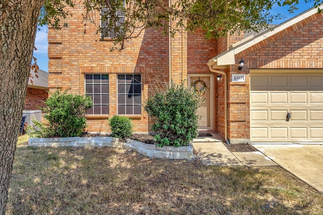 doorway to property with a garage and central AC