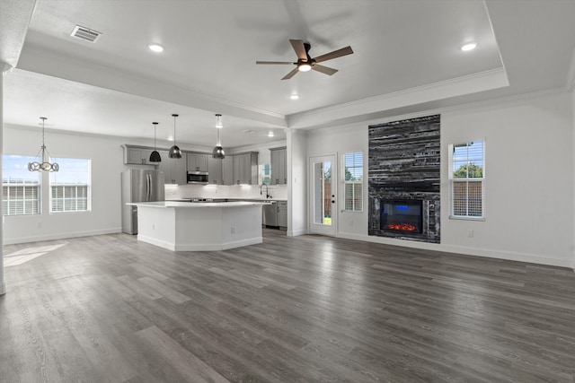 unfurnished living room with crown molding, a healthy amount of sunlight, dark hardwood / wood-style flooring, and a fireplace