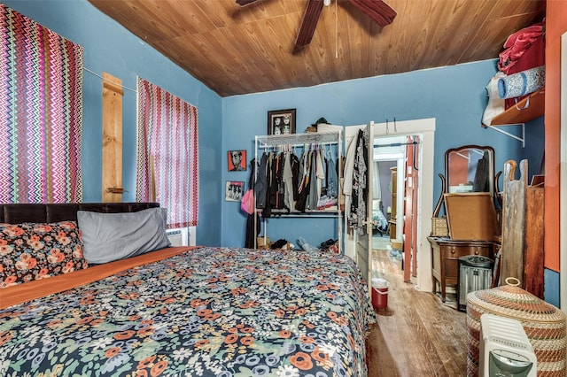 bedroom with hardwood / wood-style floors, ceiling fan, wooden ceiling, and a closet