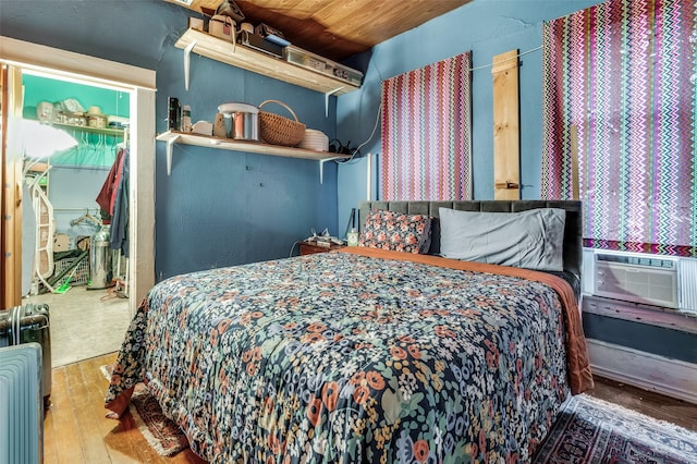 bedroom featuring wood-type flooring, radiator heating unit, cooling unit, and wood ceiling