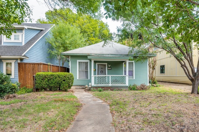 bungalow-style home with covered porch and a front lawn