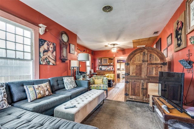 living room with wood-type flooring and ceiling fan