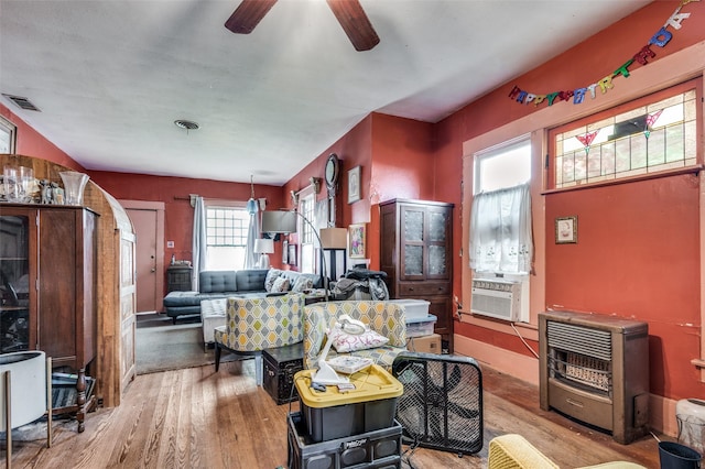 living room with hardwood / wood-style flooring, heating unit, cooling unit, and ceiling fan