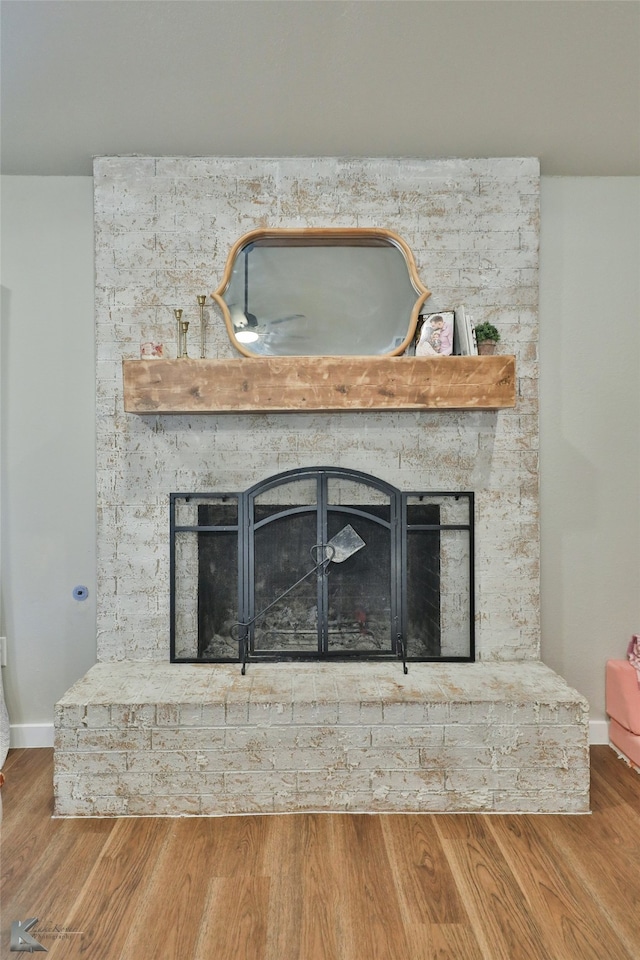 details with a brick fireplace and hardwood / wood-style flooring