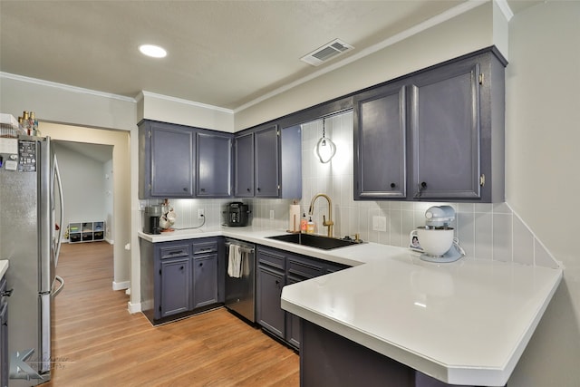 kitchen featuring backsplash, appliances with stainless steel finishes, light hardwood / wood-style floors, sink, and kitchen peninsula