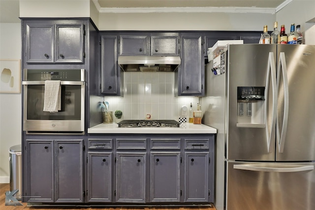 kitchen with gray cabinetry, backsplash, crown molding, stainless steel appliances, and wood-type flooring